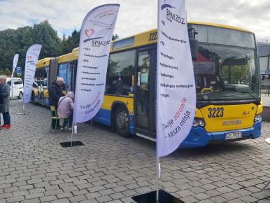 Na zdjęciu widzimy autobus komunikacji miejskiej oraz banery SPMZOZ